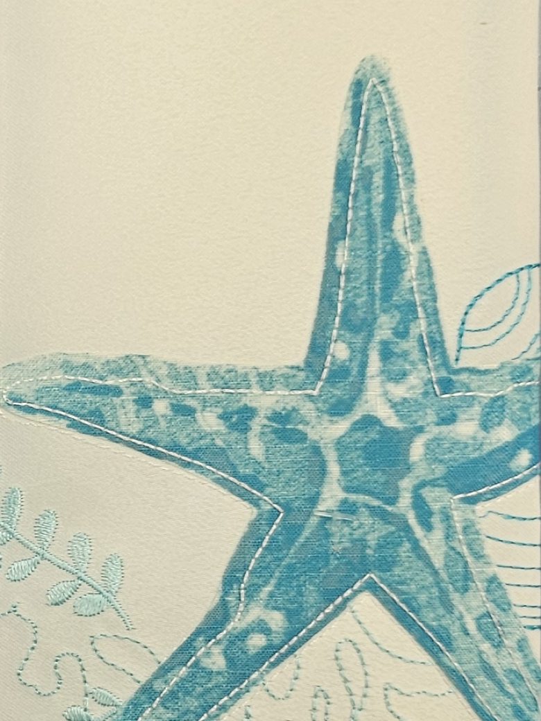 Cream guest towel embroidered with a turquoise starfish