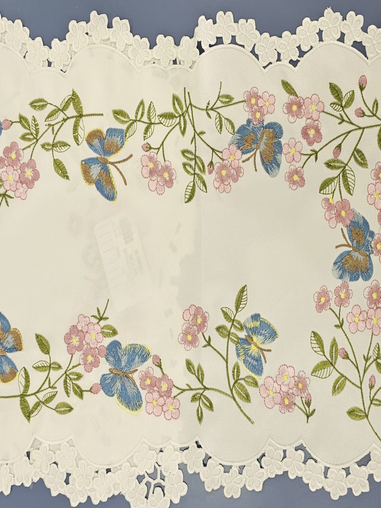 Ivory table runner embroidered with blue butterflies and pink blossom, edged in daisy lace