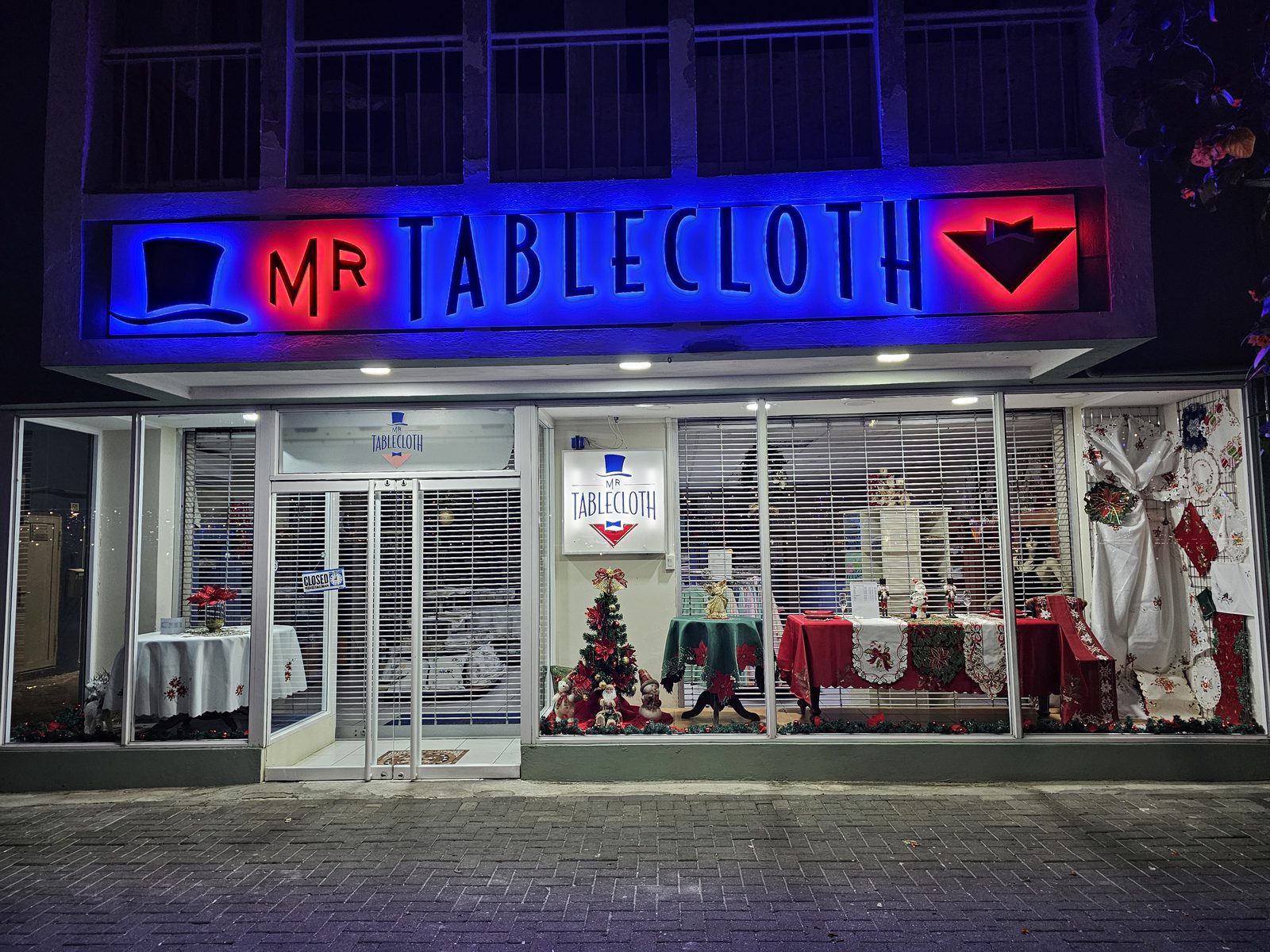 Mr. Tablecloth storefront lit up at night on Handelskade